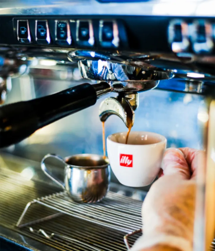 Espresso pouring into an illy cup at the bar