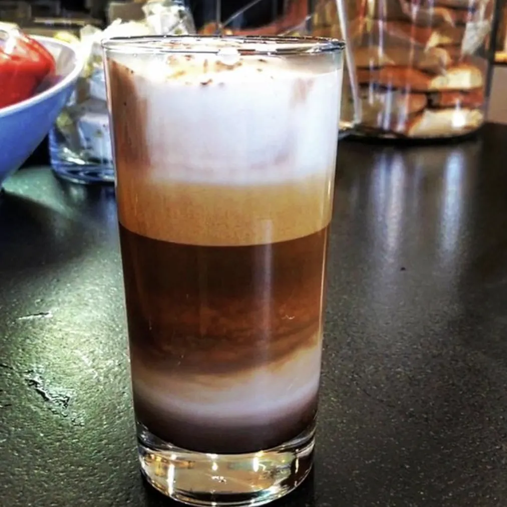 A layered latte in a glass