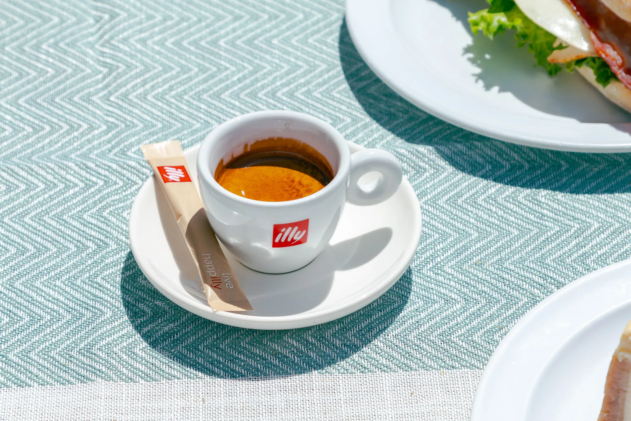 Espresso in an illy cup on a patio table